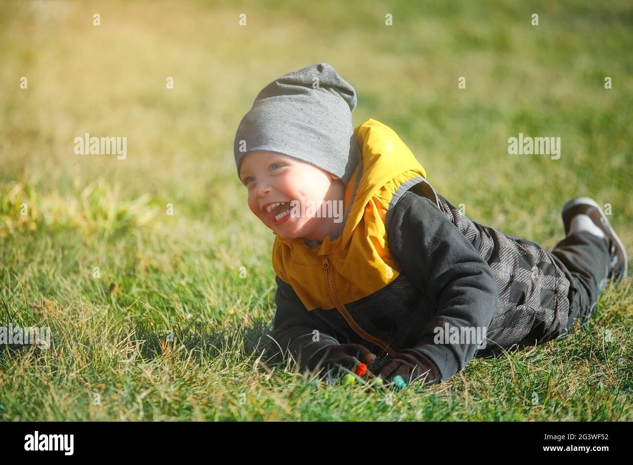 Emotional portrait of a Caucasian boy in an autumn park on a walk. Stock Photo