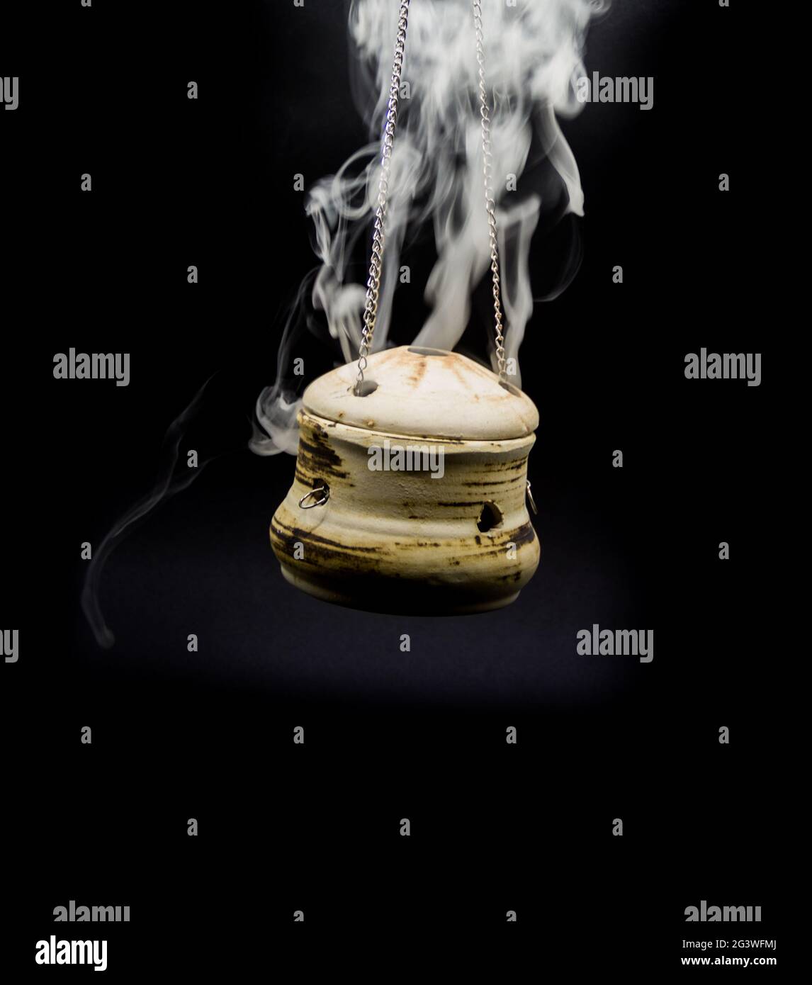 Bowl of incense hanging smoke on black background Stock Photo - Alamy