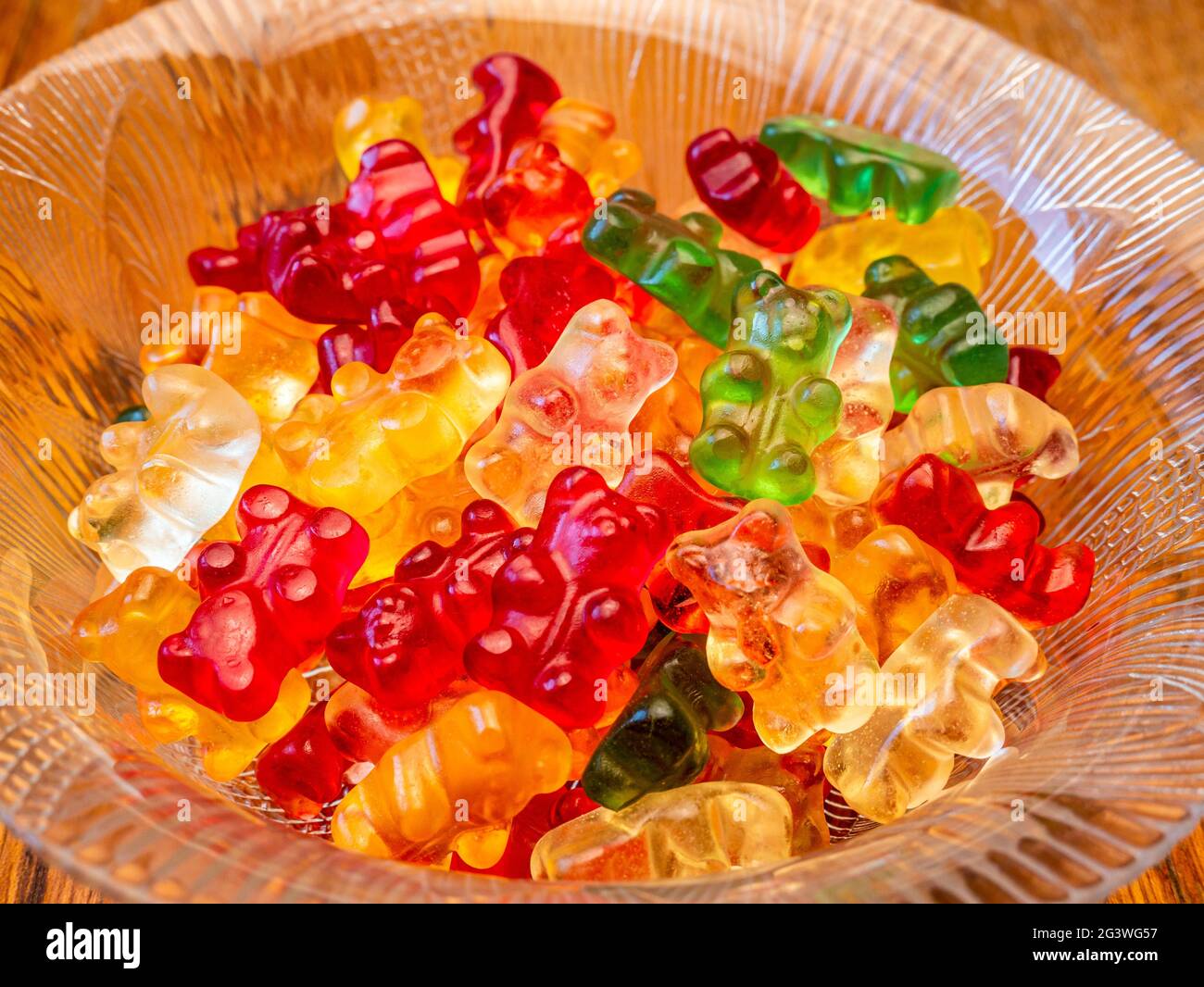 Glass bowl with colorful gummy bears, on a wooden background - selective focus Stock Photo