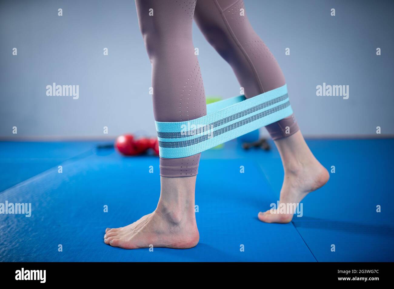 Legs woman barefoot doing pilates exercise with elastic fabric resistance band. Resistance Bands for butt and Legs, Exercise ban Stock Photo