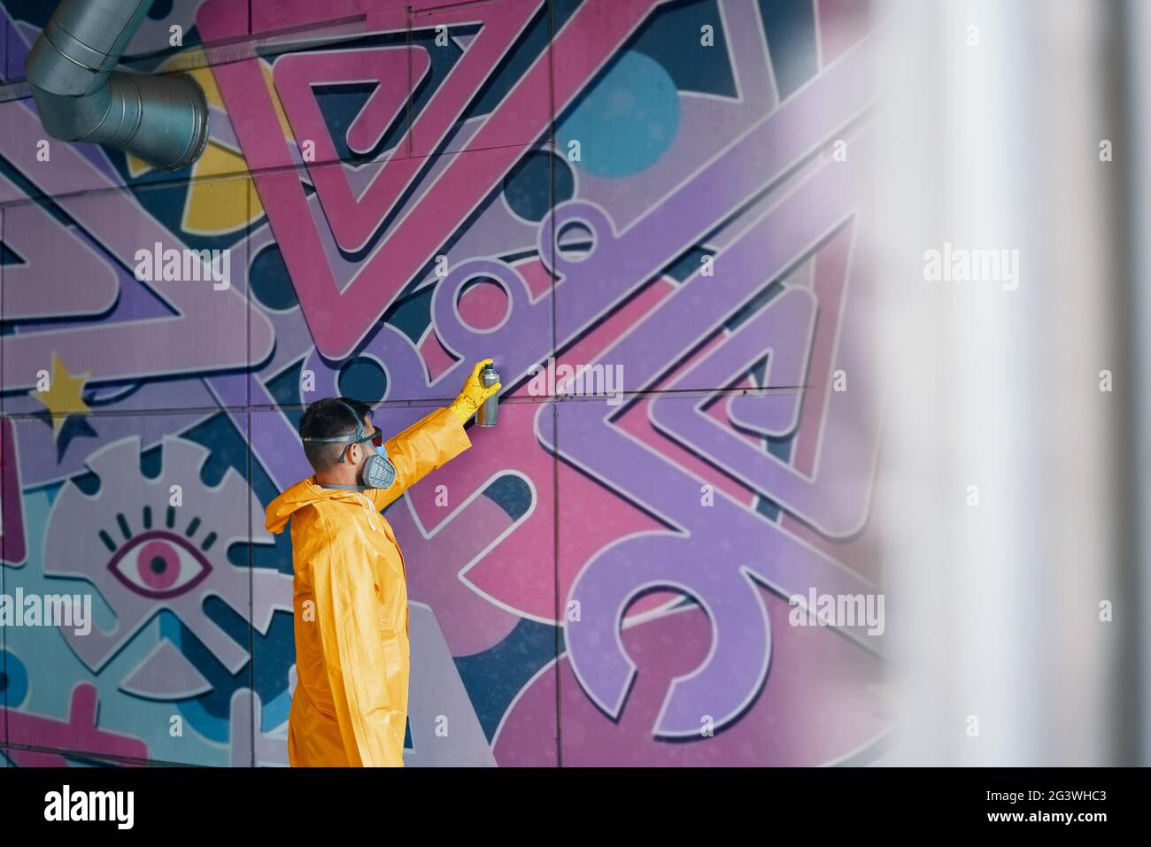 Street artist painting colorful graffiti on wall Stock Photo - Alamy