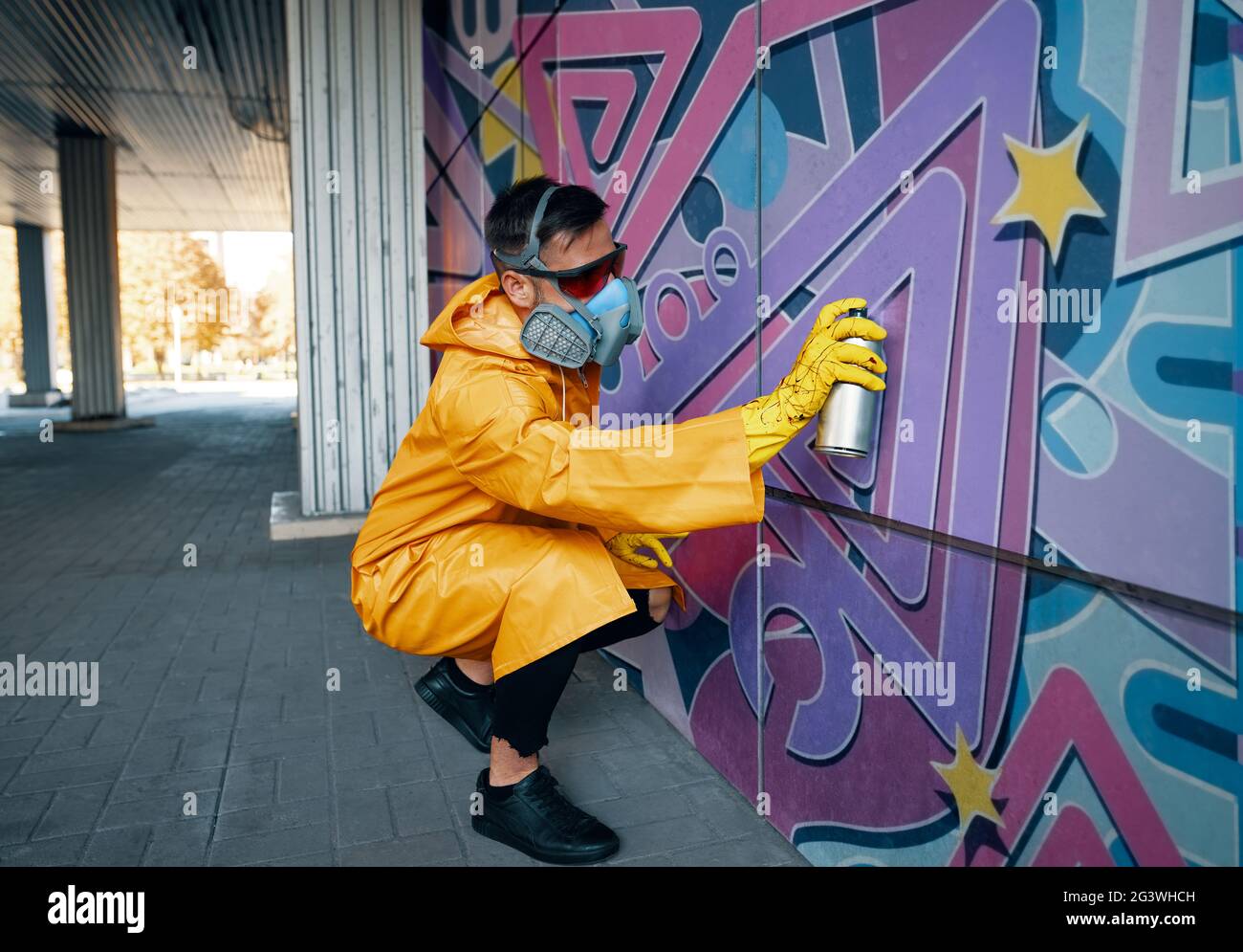 Street artist painting colorful graffiti on wall Stock Photo - Alamy