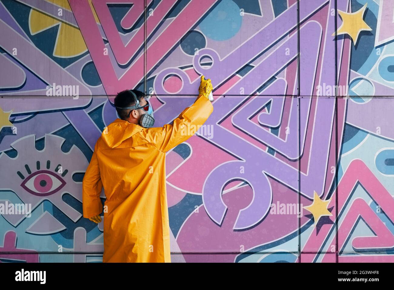 Street artist painting colorful graffiti on wall Stock Photo - Alamy
