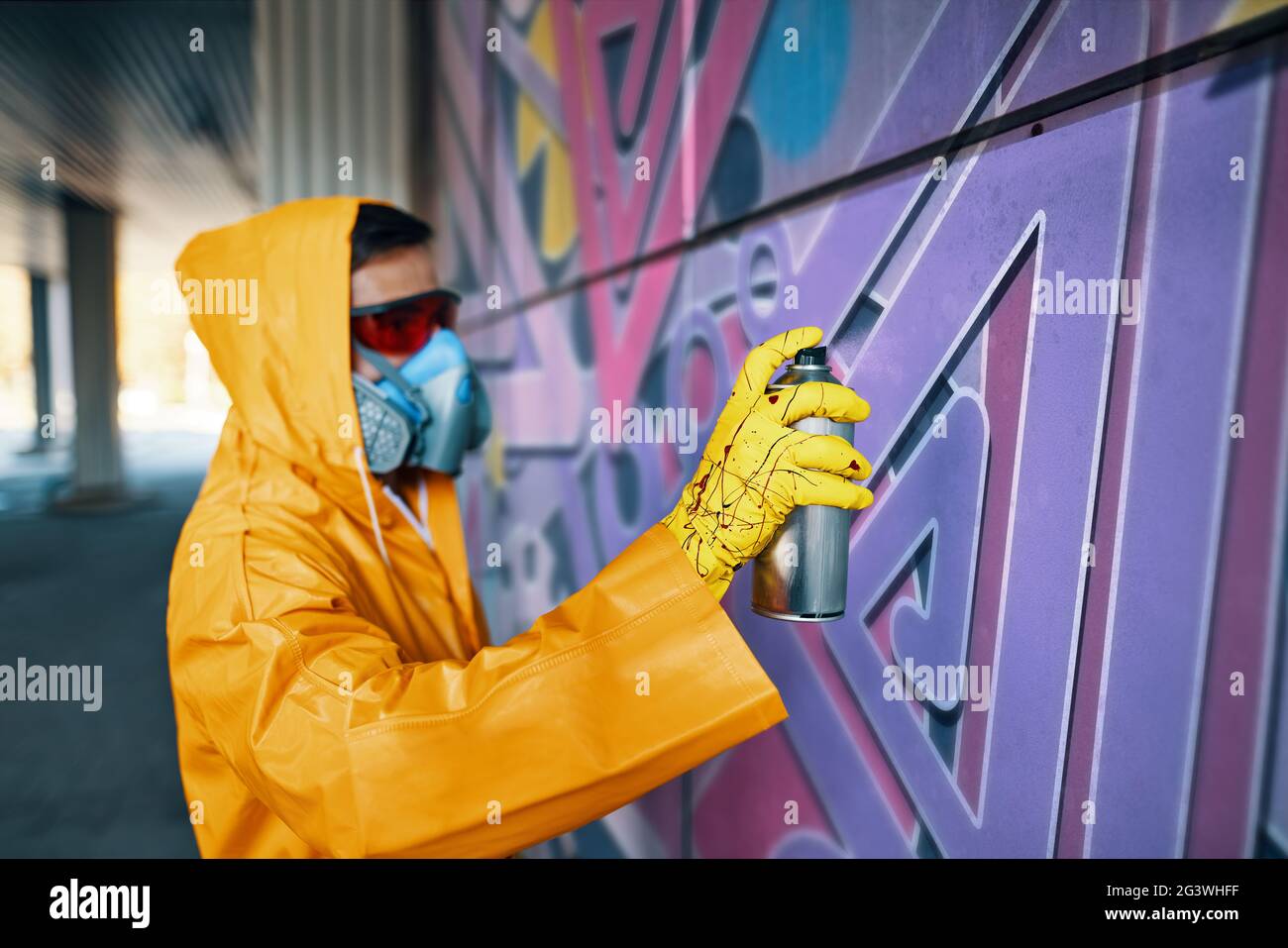 Street artist painting colorful graffiti on wall Stock Photo - Alamy