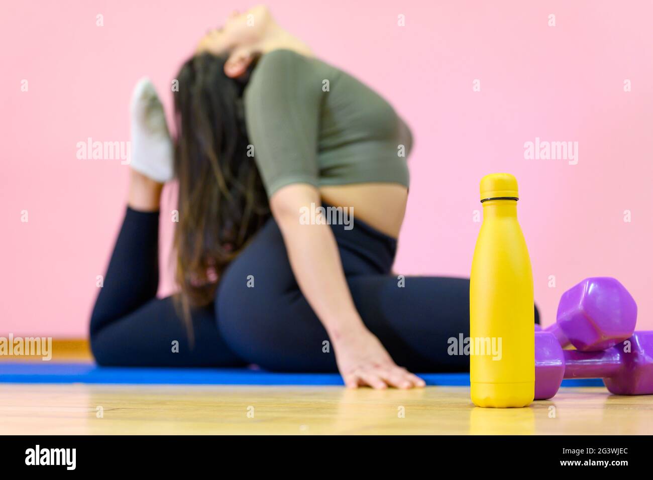 Flexible Woman practicing stretching exercises On Yoga Mat Stock Photo ...