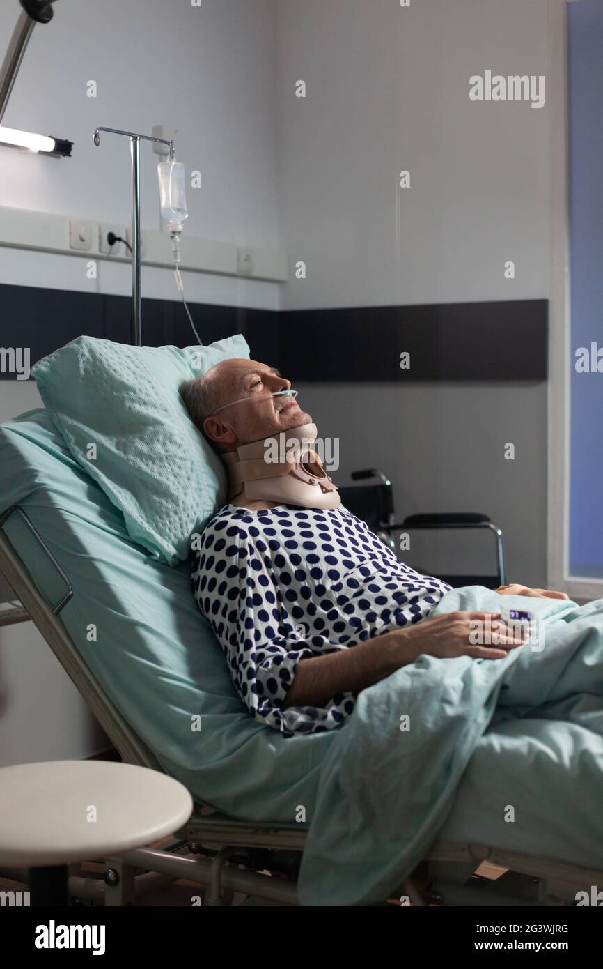 Senior man suffering after serious accident laying in hospital bed