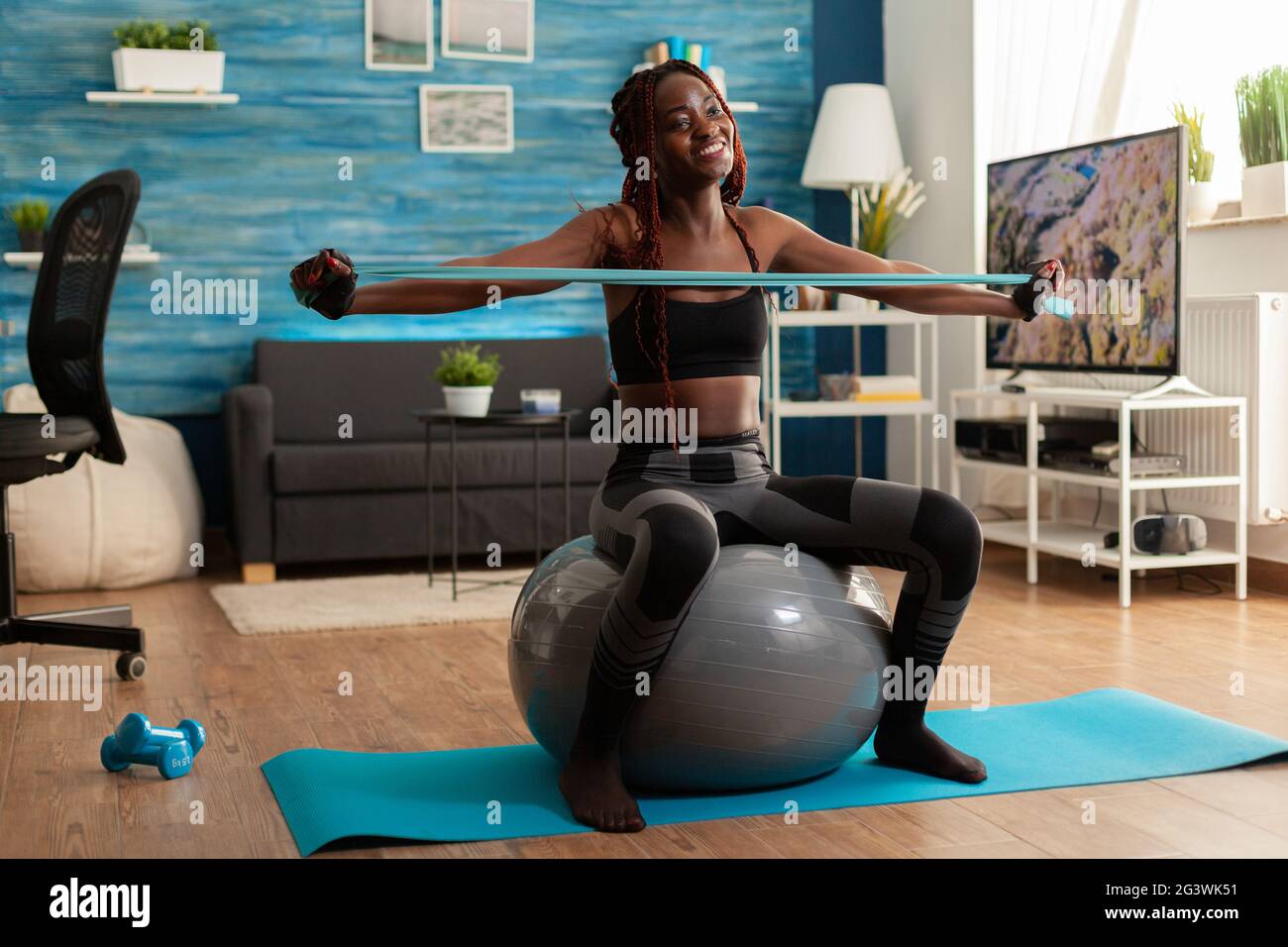 Athletic fit joyful black woman working out back muscle with rubber ...