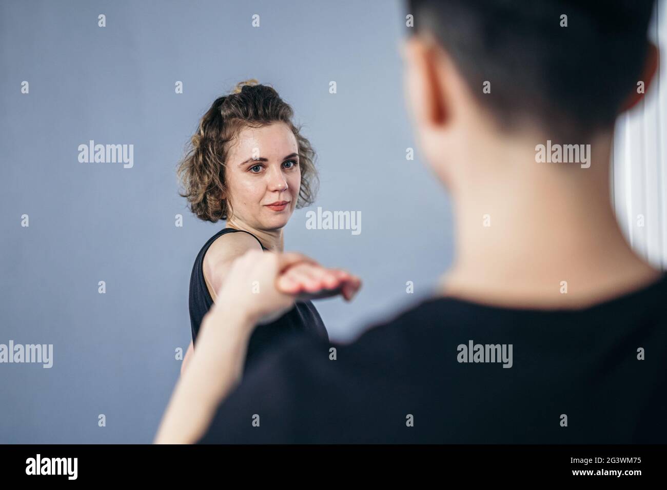 Two female fighter of martial arts practice in gym. Taekwondo coach and student in personal training. Self-defense class for wom Stock Photo