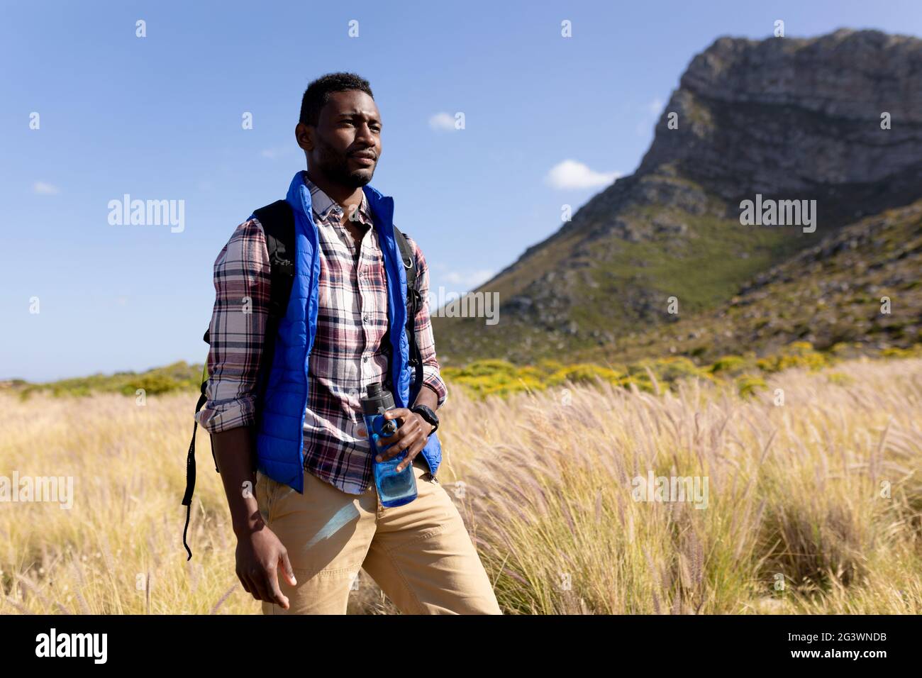 Fit afrcan american man wearing backpack hiking in mountain countryside ...