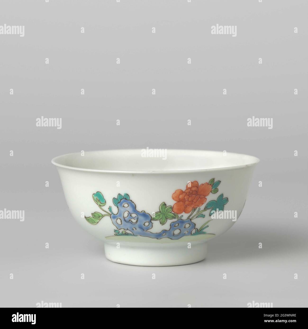 Bell-Shaped Bowl With Flower Sprays and a Flowering Plant Near a Rock. Bell-shaped bowl of porcelain, painted in underglaze blue and on the glaze blue, red, green, yellow, black and gold. On the outer wall on one side a chrysantheate branch and a bamboo roof, the other side with a blossoming peony plant at a rock. Marked on the underside with a seal mark in a double circle. A chip in the edge; Some chips in the bottom. Famille Verte. Stock Photo