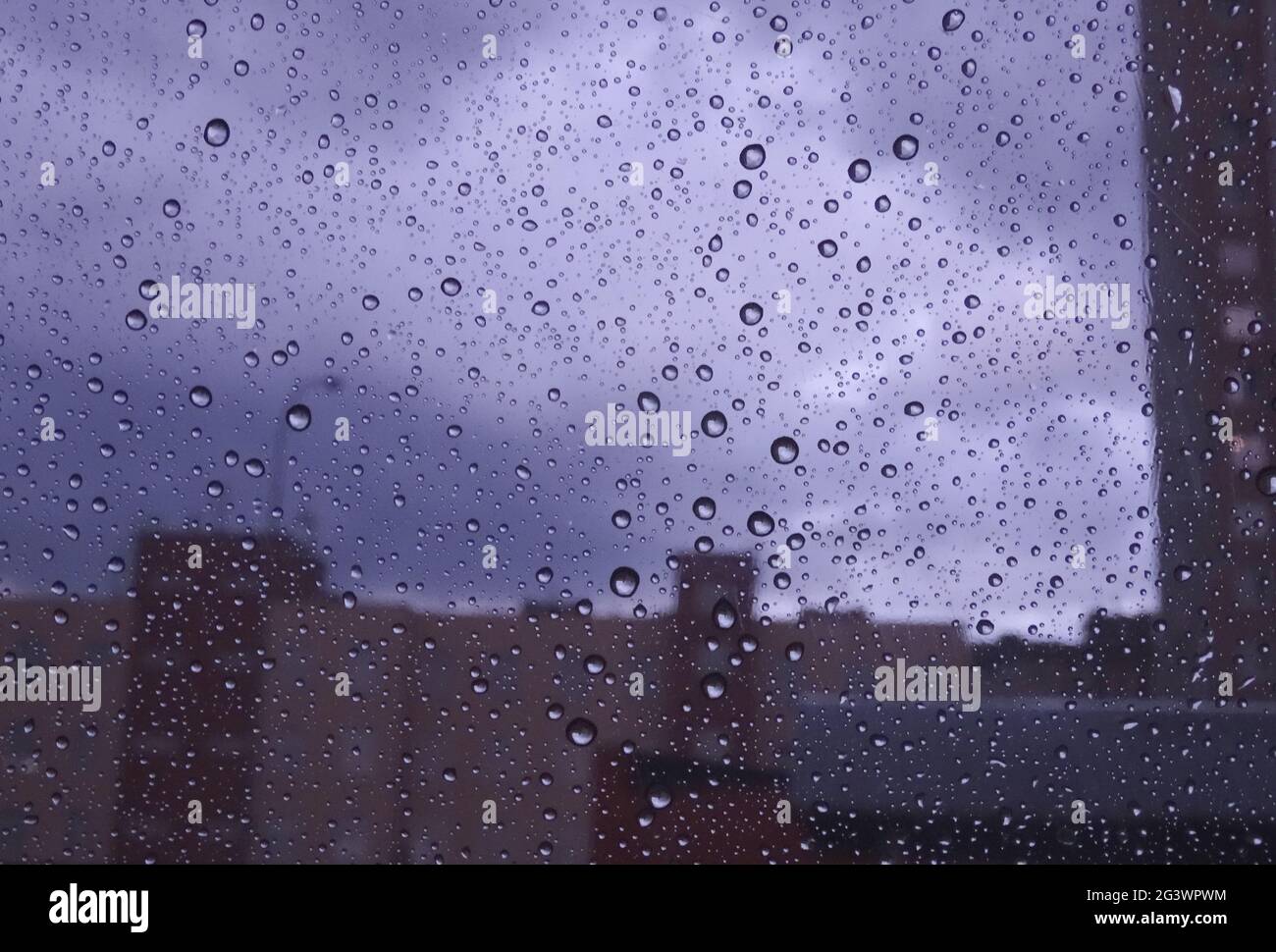 Soft Focus Modern Buildings In Wet Window Glass Stock Photo