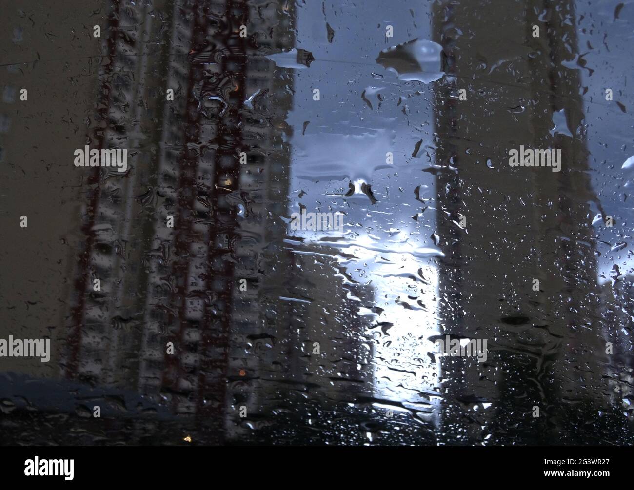 Soft Focus Modern Buildings In Wet Window Glass Stock Photo