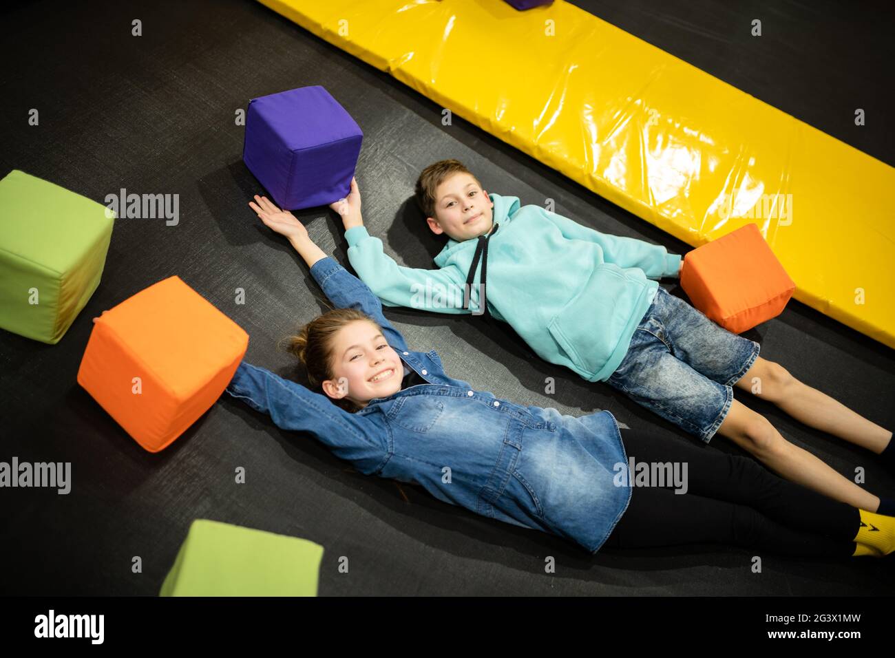 Active leisure. Children having fun on trampoline in entertainment center, childhood and sporty lifestyle. Boy and girl in leisu Stock Photo