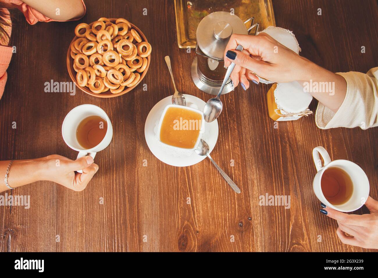 Two young girls are drinking green tea with honey after bathing spa