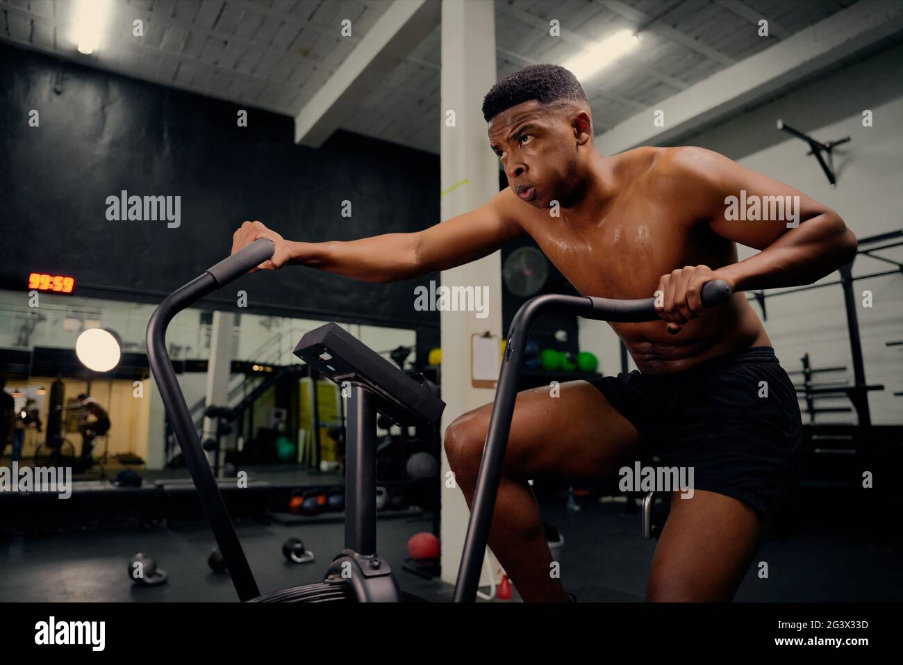 African American male using an elliptical trainer during cross fit  training. Male athlete exercising intensely in the gym. High quality photo  Stock Photo - Alamy