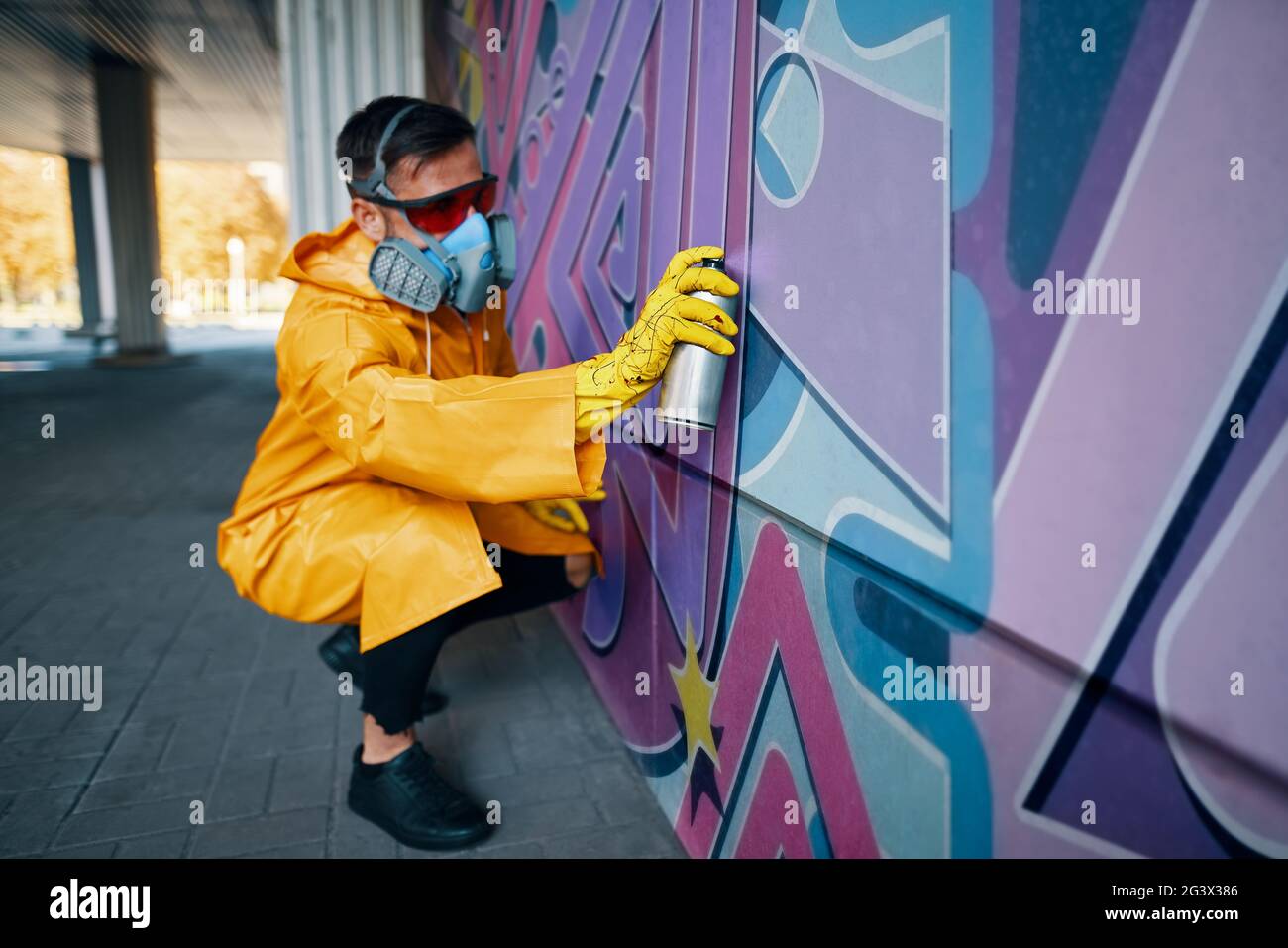 Street artist painting colorful graffiti on wall Stock Photo - Alamy