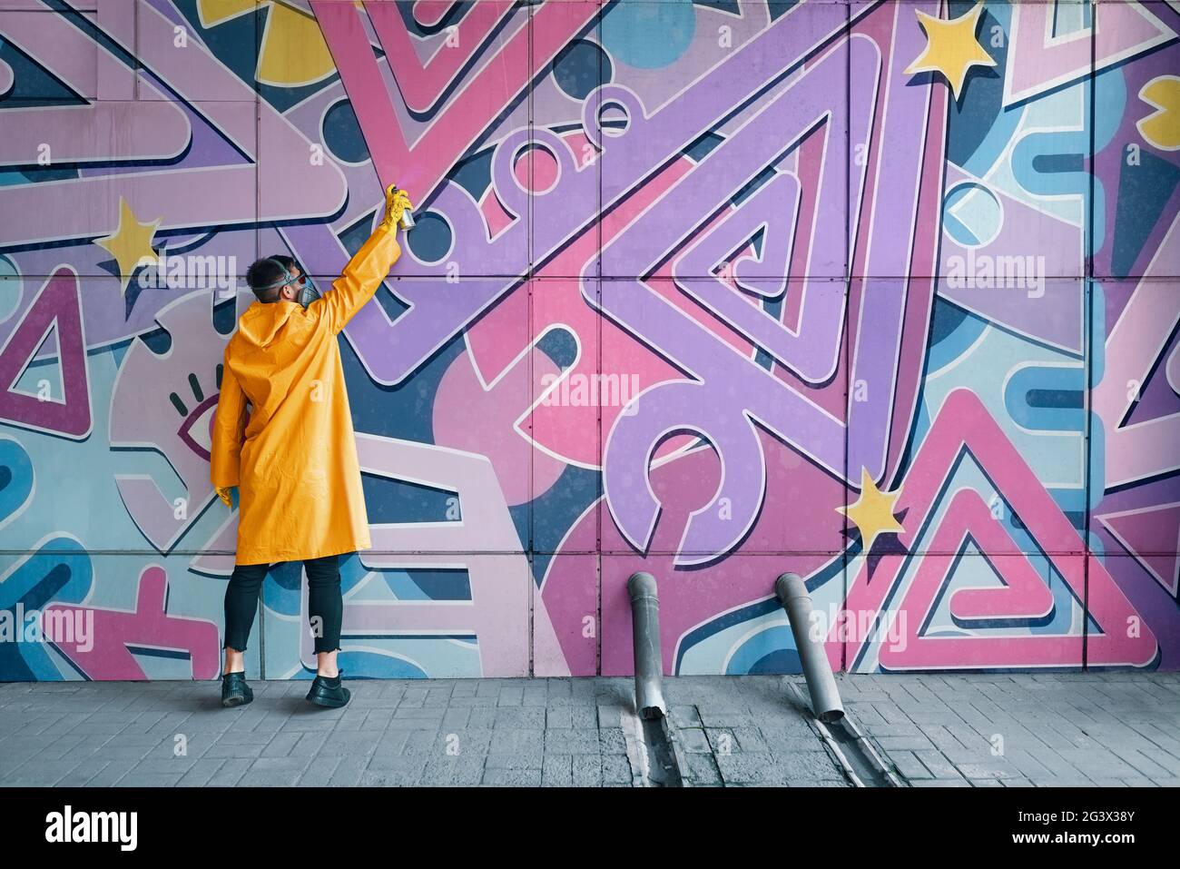 Street artist painting colorful graffiti on wall Stock Photo - Alamy