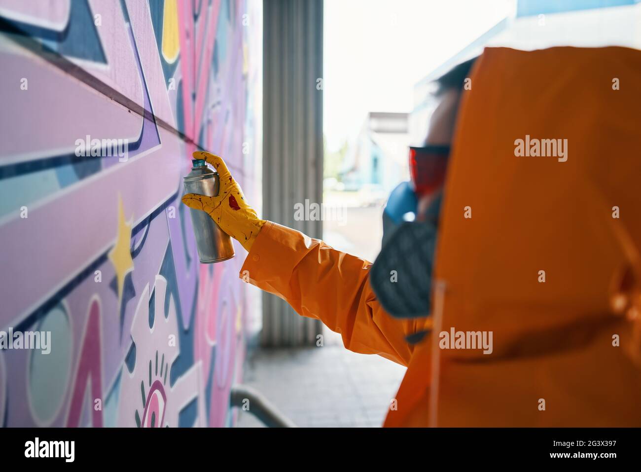 Street artist painting colorful graffiti on wall Stock Photo - Alamy