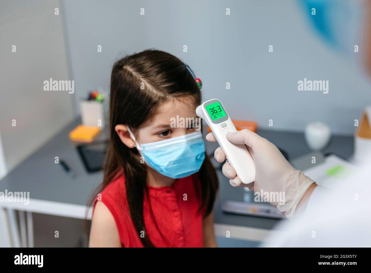 Girl without fever whose temperature is taken by her doctor Stock Photo Alamy