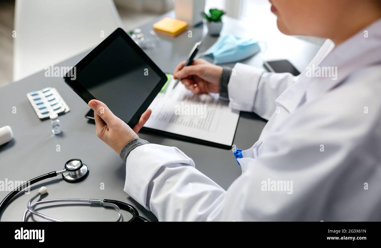 Unrecognizable female doctor using tablet while working Stock Photo