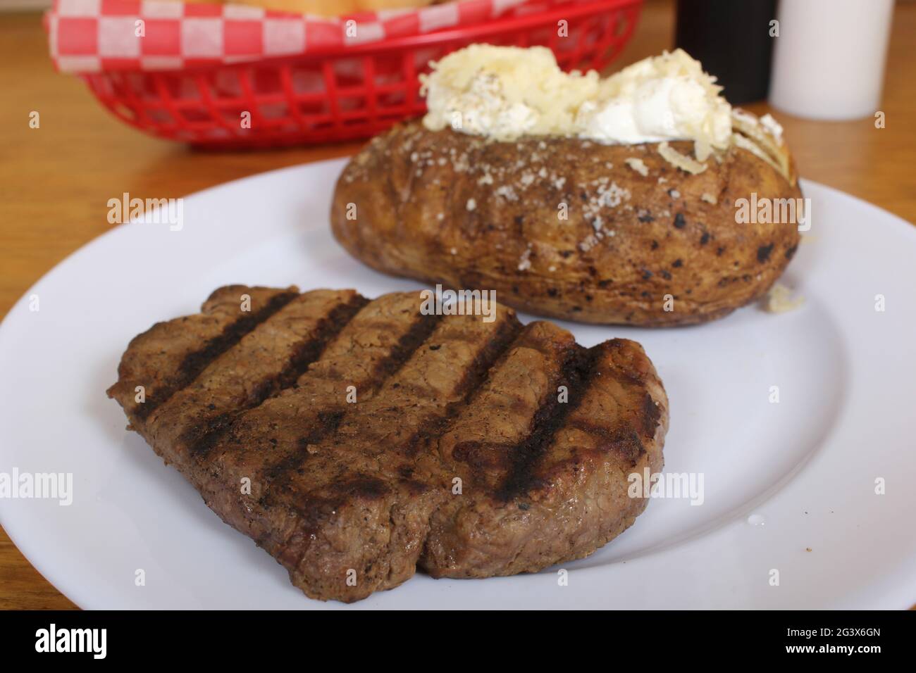 Sirloin Steak With Baked Potato and fresh rolls Stock Photo - Alamy