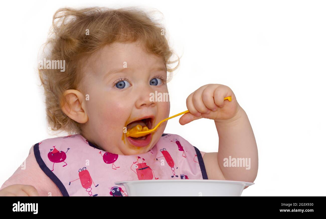 Toddler eats independently Stock Photo