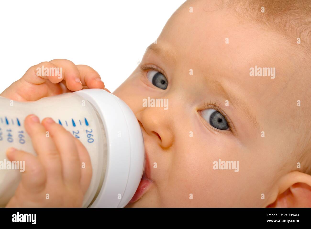 Baby drinks independently from milk bottle Stock Photo