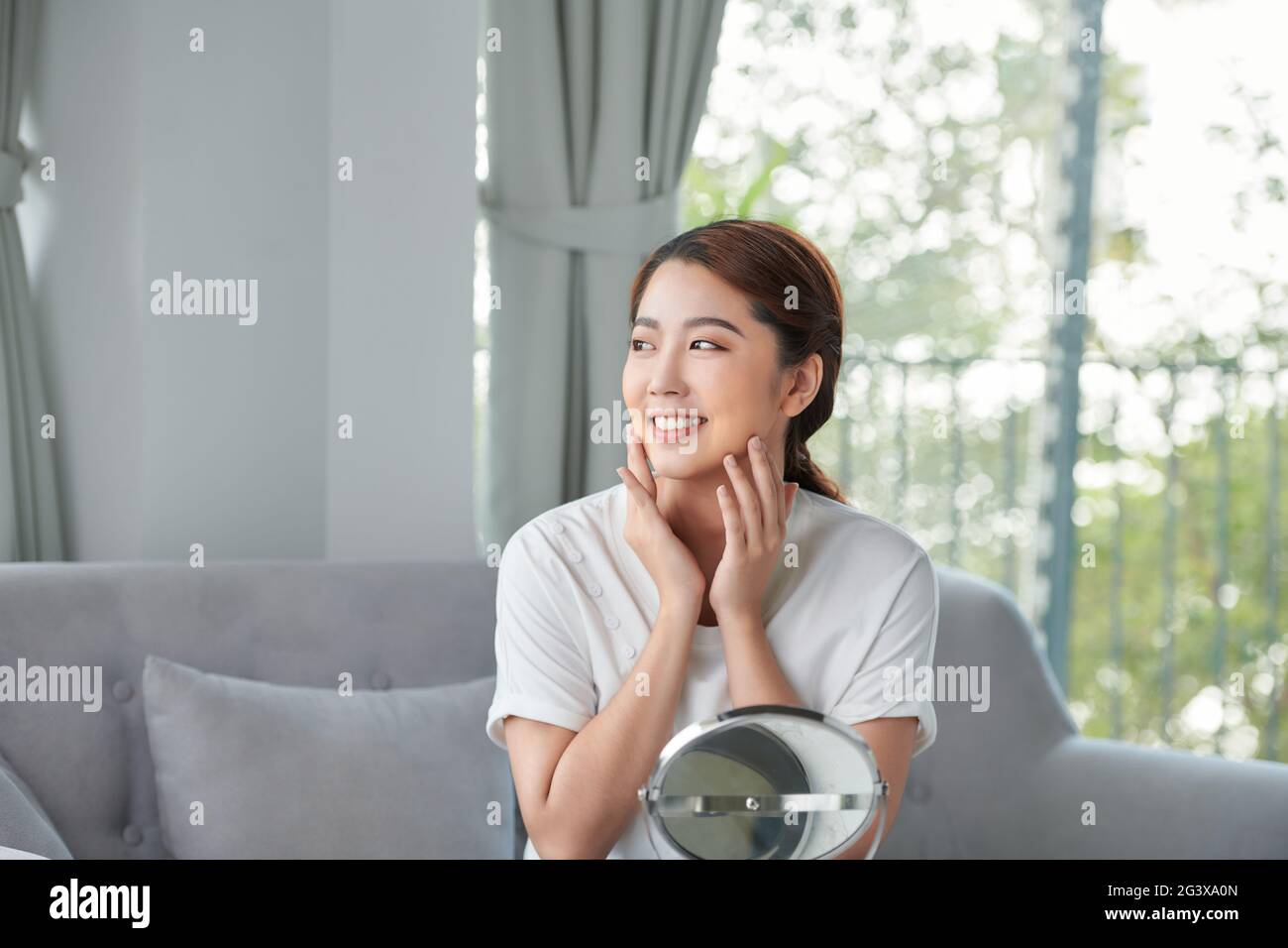 Beauty skin care. Young beautiful asian girl touching her face before ...