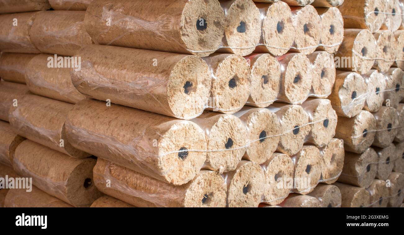 Fire briquettes for heating: Stacked firewood packed in plastic Stock Photo