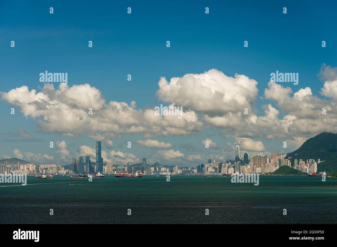 The city skyline of Kowloon and Hong Kong Island, viewed from Lantau Island to the west, in the afternoon on a clear summer day Stock Photo