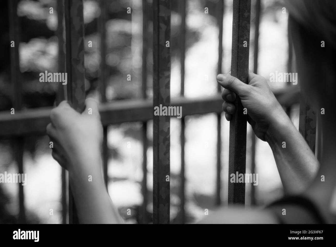 Prison cell: Close up of hands in jail Stock Photo