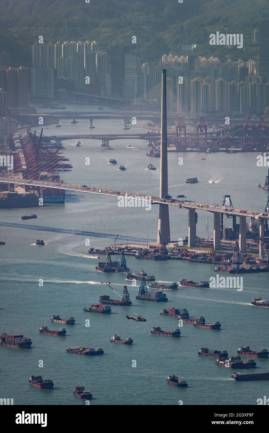 Barges and lighters used for mid-stream transfer of shipping containers to and from ships moored outside Hong Kong's container port, Victoria Harbour Stock Photo