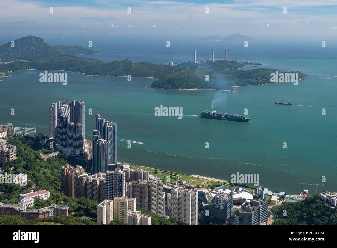 Ships in East Lamma Channel steam past tech hub Cyberport and the high-rise residential towers of Residence Bel-Air in Pok Fu Lam, Hong Kong Island Stock Photo