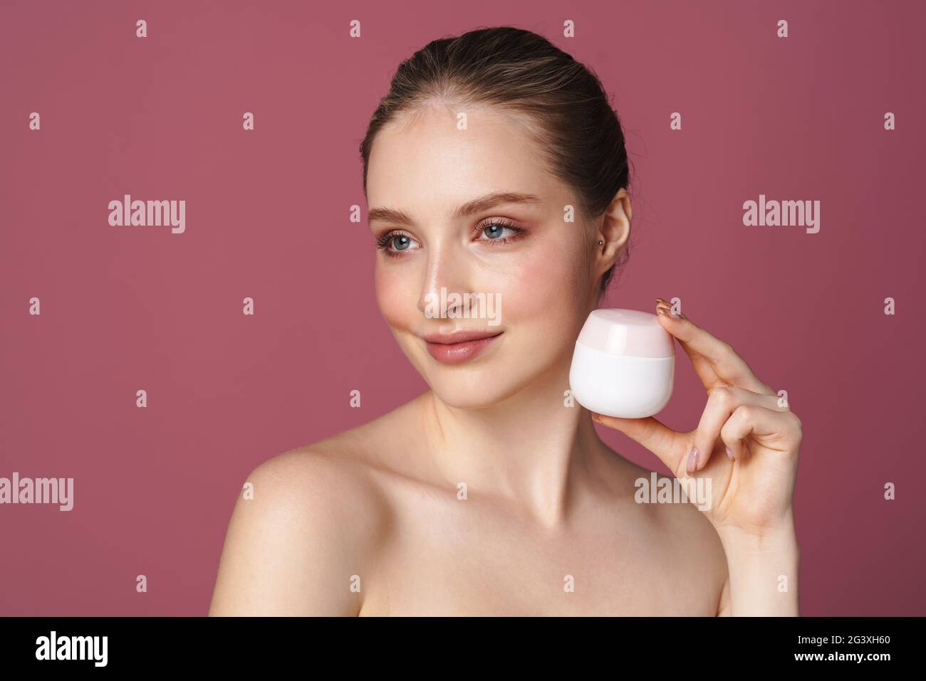 Close up beauty portrait of an attractive young woman showing jar of ...