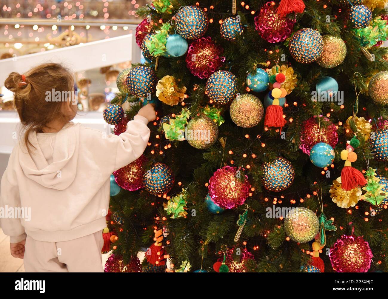 Paris (France): Christmas decorations in the Galeries Lafayette department store on December 15, 2020. Little girl in front of a decorated Christmas t Stock Photo