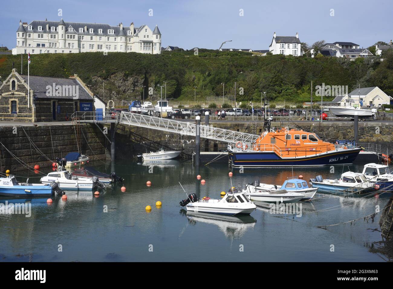 Portpatrick's picturesque harbour with the RNLI Portpatrick Lifeboat Station, with lifeboat and other small boats moored. Portpatrick, Rhins of Gallow Stock Photo