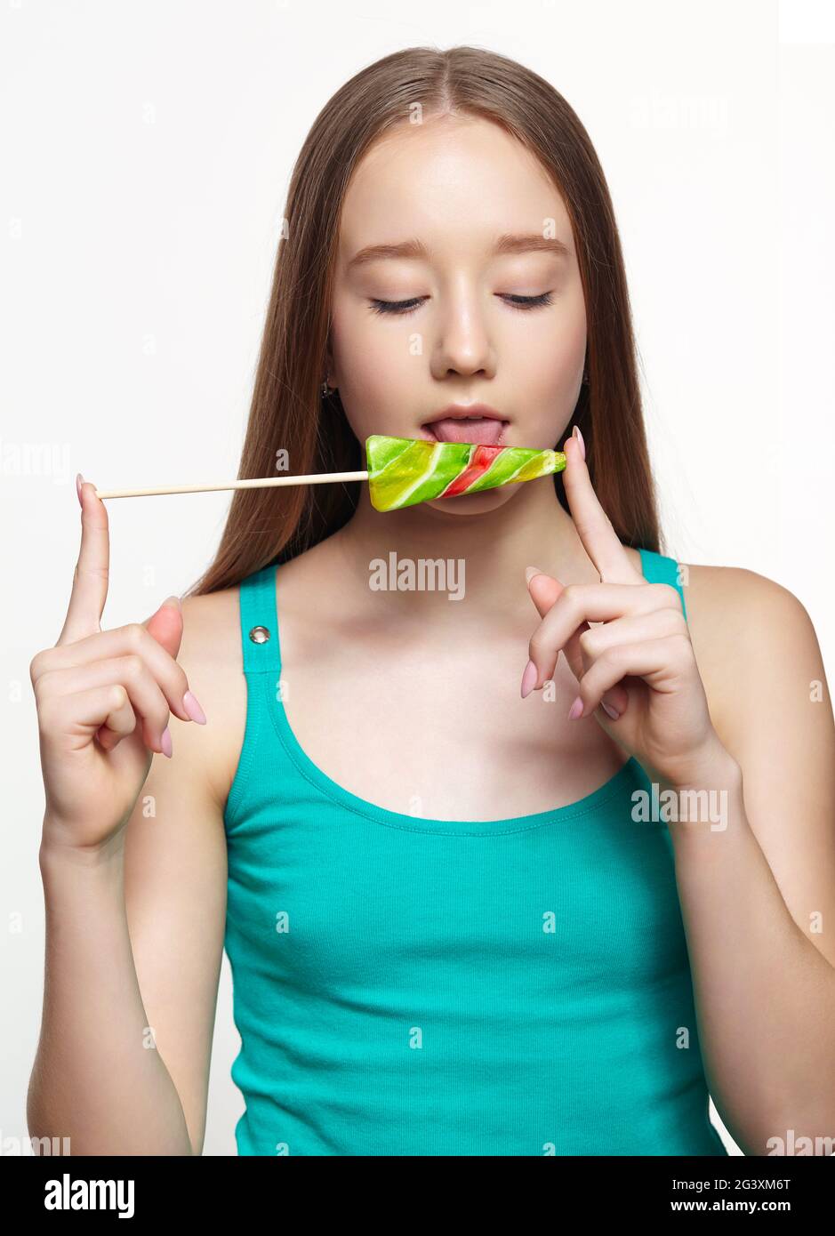 Teenager girl licking the lollipop. Sweet tooth concept Stock Photo