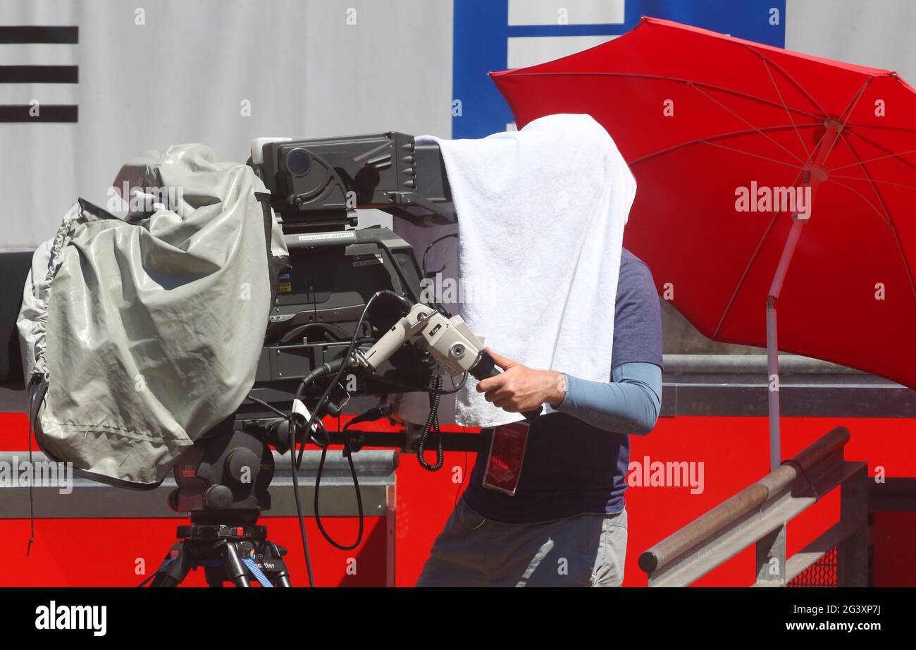 Berlin, Germany. 18th June, 2021. Tennis, WTA Tour, Singles, Quarterfinals  Bencic (Switzerland) - Alexandrowa (Russia), Steffi-Graf-Stadion: With  temperatures around 37 degrees Celsius, a cameraman protects himself from  the glaring sun with a