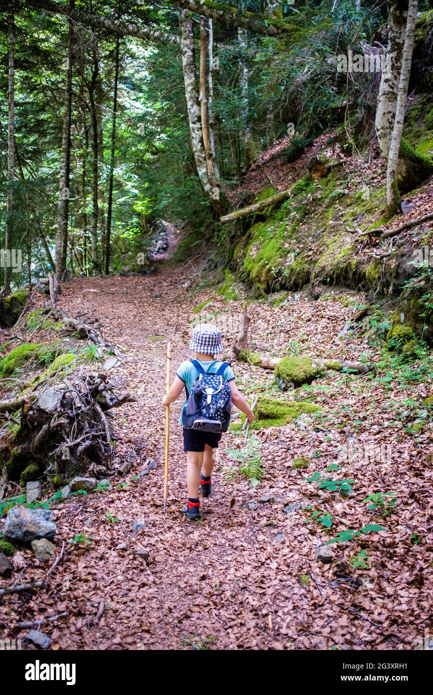 Child walking on a mountain path, hike in Aure Valley near Tramezaigues, in the Hautes Pyrenees department (Upper Pyrenees, south western France) Stock Photo