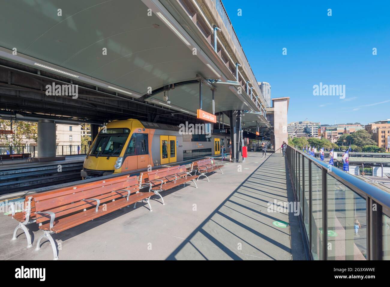 A train pulls into one of the platforms of Circular Quay Railway Station that overlooks Sydney Harbour, on a sunny morning in Australia Stock Photo