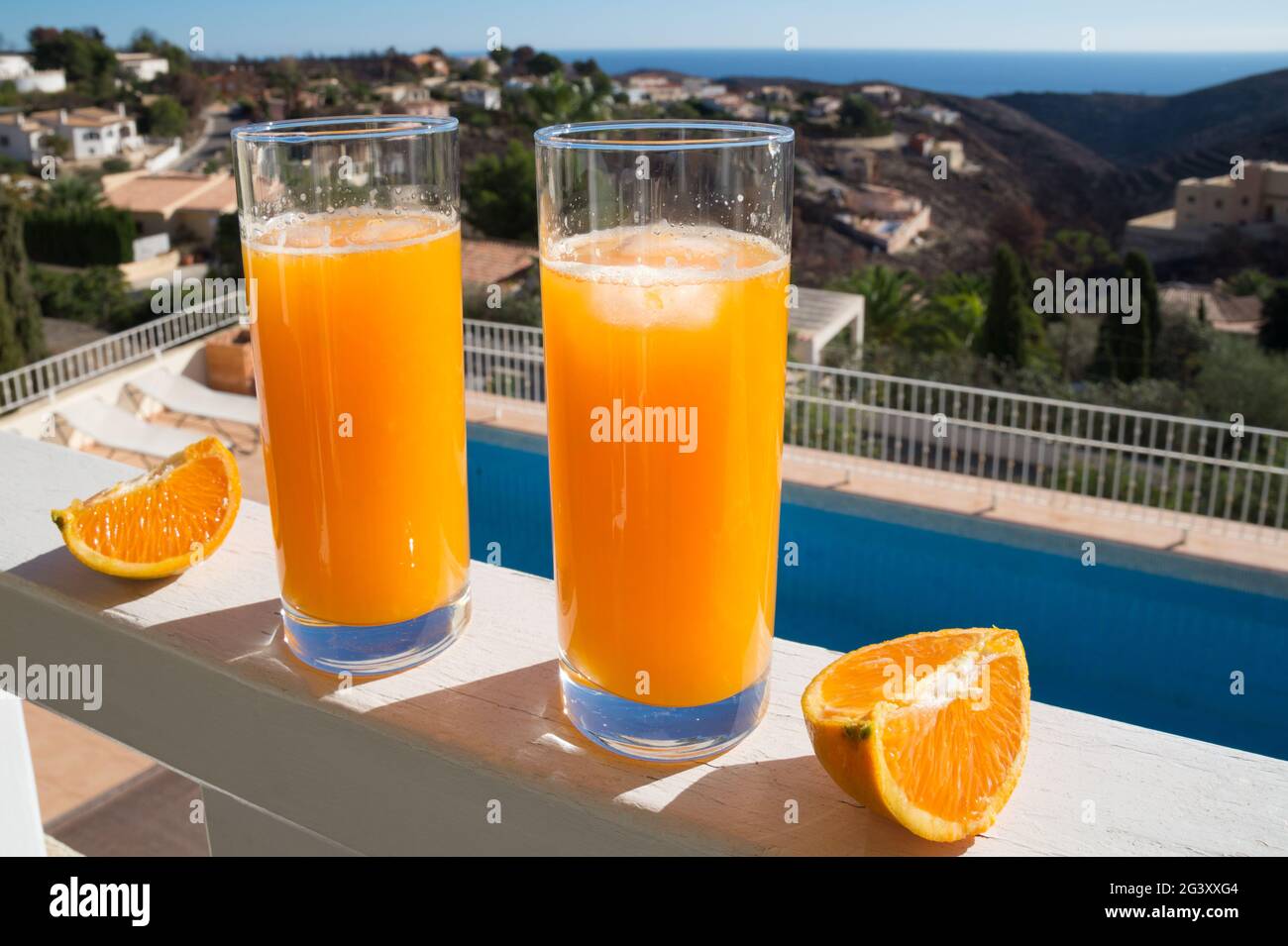 natural orange juice in the mediterranean sunlight and a beautiful view of the sea Stock Photo
