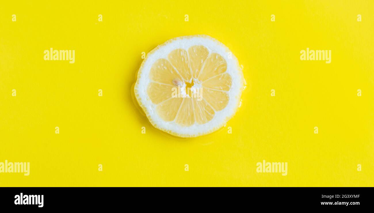 Intense yellow lemon citrus slice in water, texture summer background ...
