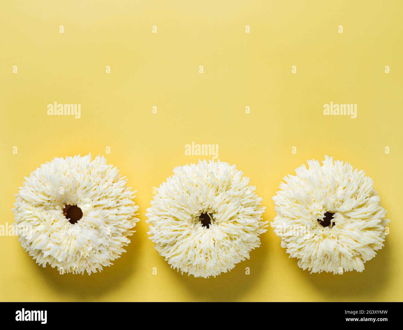 Shag donuts on yellow background, copy space Stock Photo