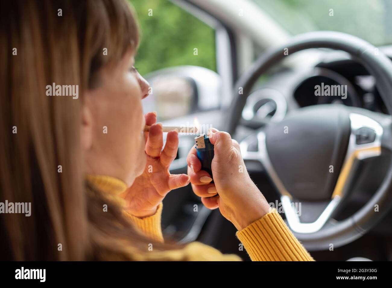 Woman lighting a cigarette in car Stock Photo Alamy