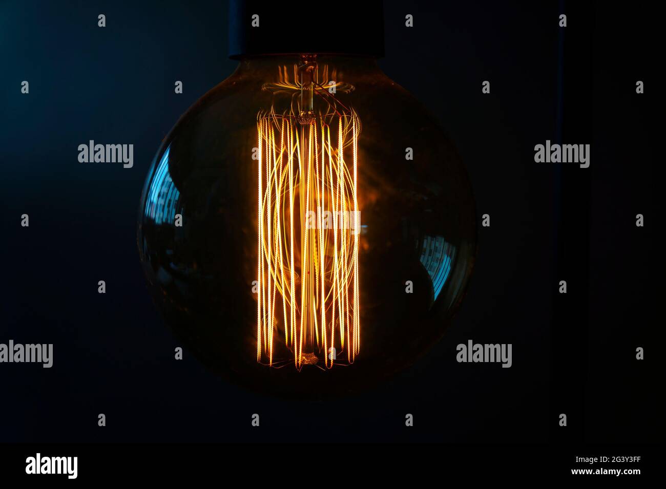 Close-up of a glowing incandescent light bulb filaments Stock Photo