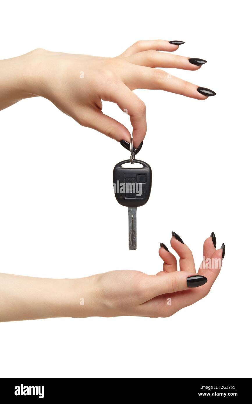 A female hand with a black nails manicure holds a black car key with