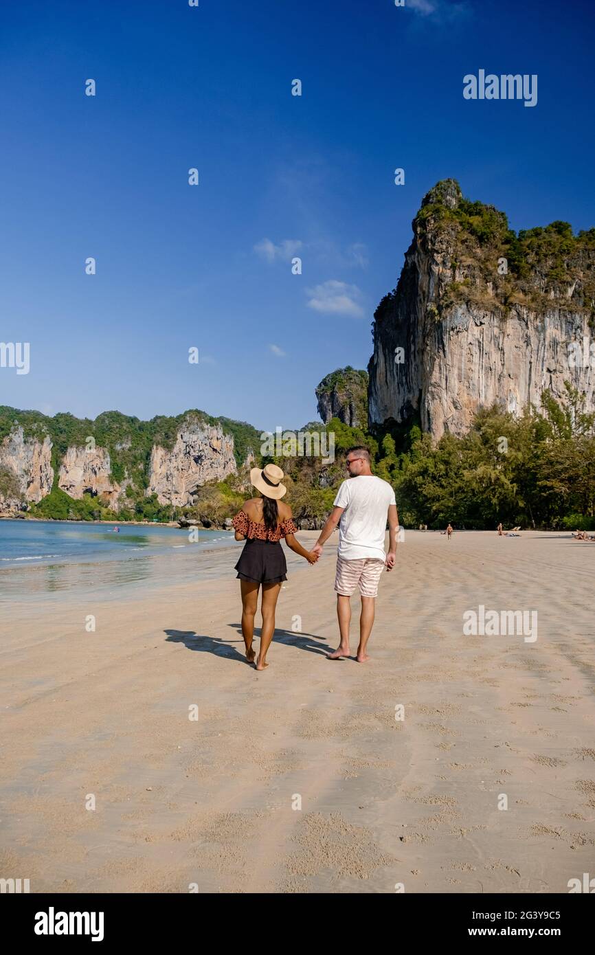 Couple mid age on tropical beach in Thailand, tourist walking on a white tropical beach, Railay beach with on the background lon Stock Photo