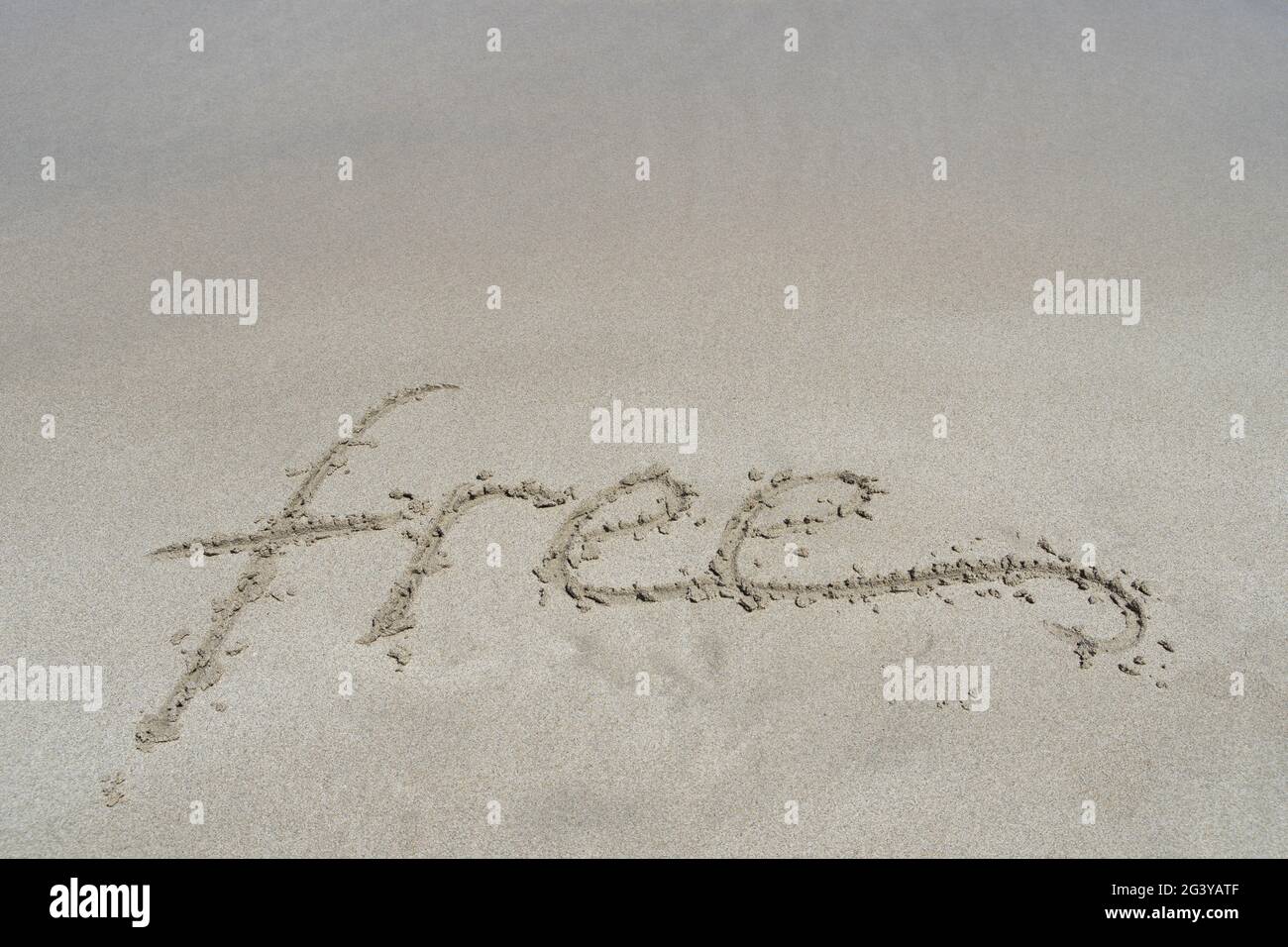 free emotion handwriting in fine sand on the beach inspirational background Stock Photo
