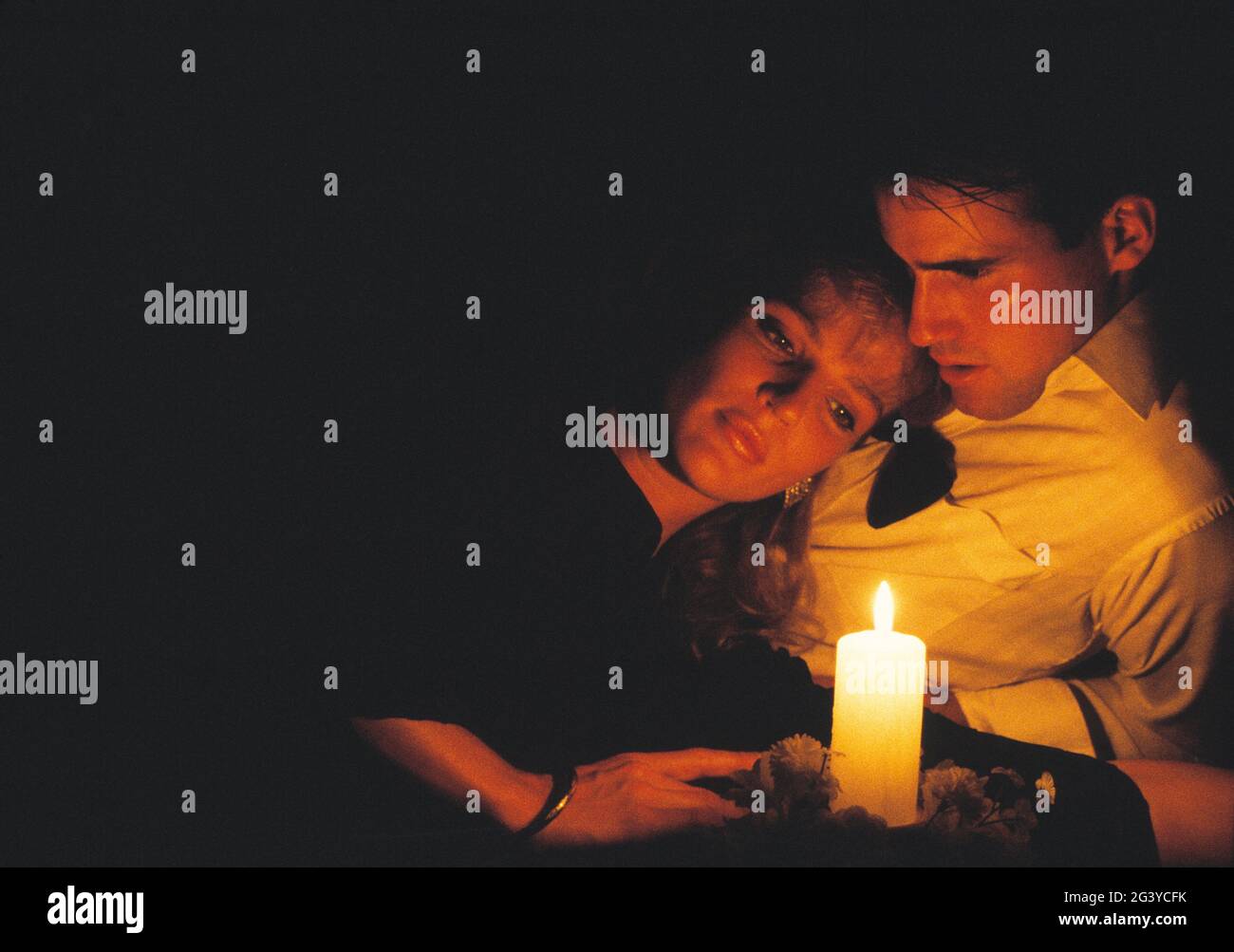Close up of young, romantic couple indoors by candlelight. Stock Photo