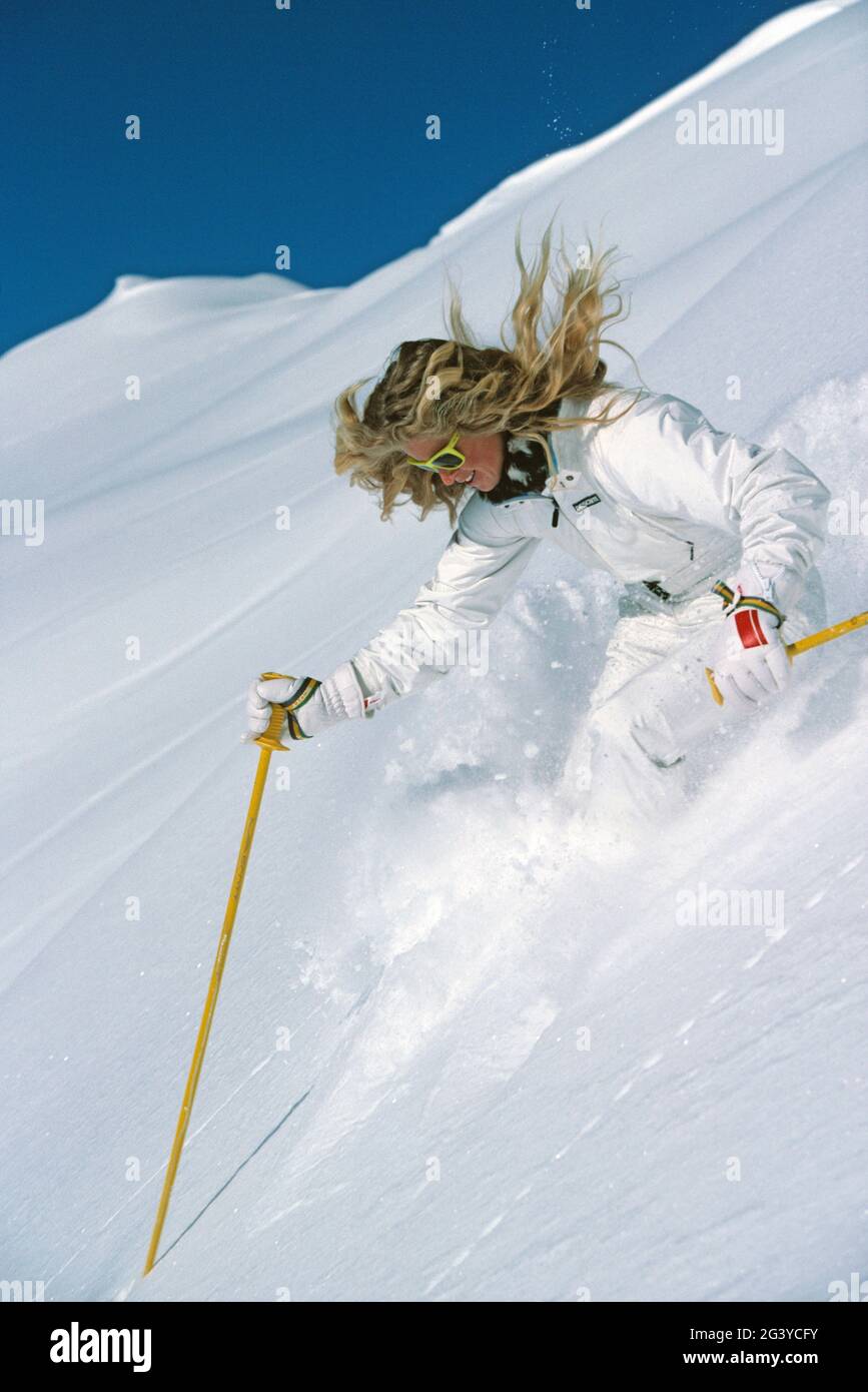 New Zealand. Sport. Snow skiing. Young blond woman downhill skiing. Stock Photo